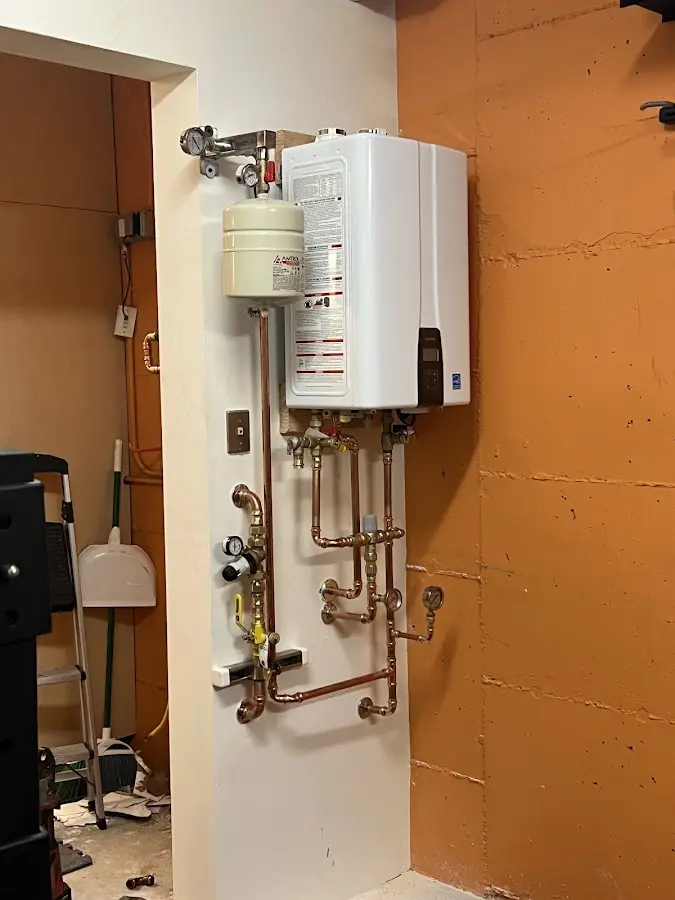 Plumbing technician inspecting water heater connections in Linda